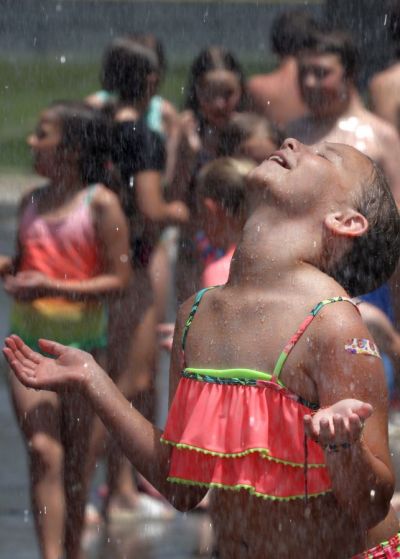 SWEET RELIEF — Marilee Holt, 9, lifts her head as water, sprayed from a Washington firetruck, rains down on her and other Camp Washington campers June 15 near Main Park. (June 18-19, 2022, weekend edition) [Julia Hansen | The Missourian (Washington Missouri)]